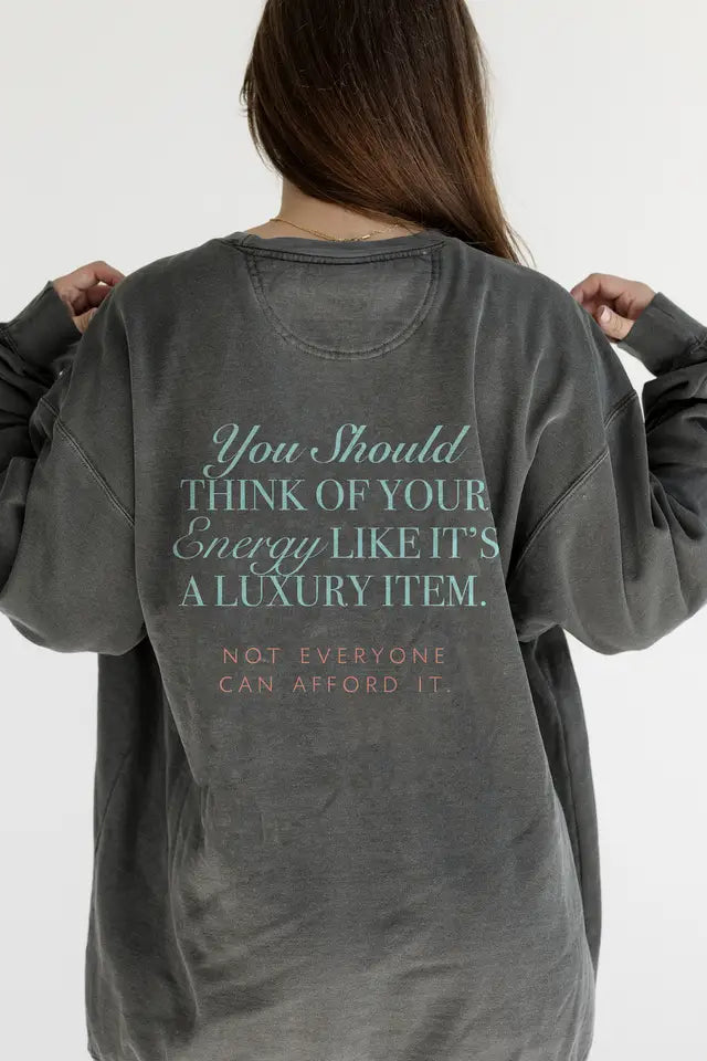 Person wearing a gray sweatshirt with motivational text on the back against a white background
