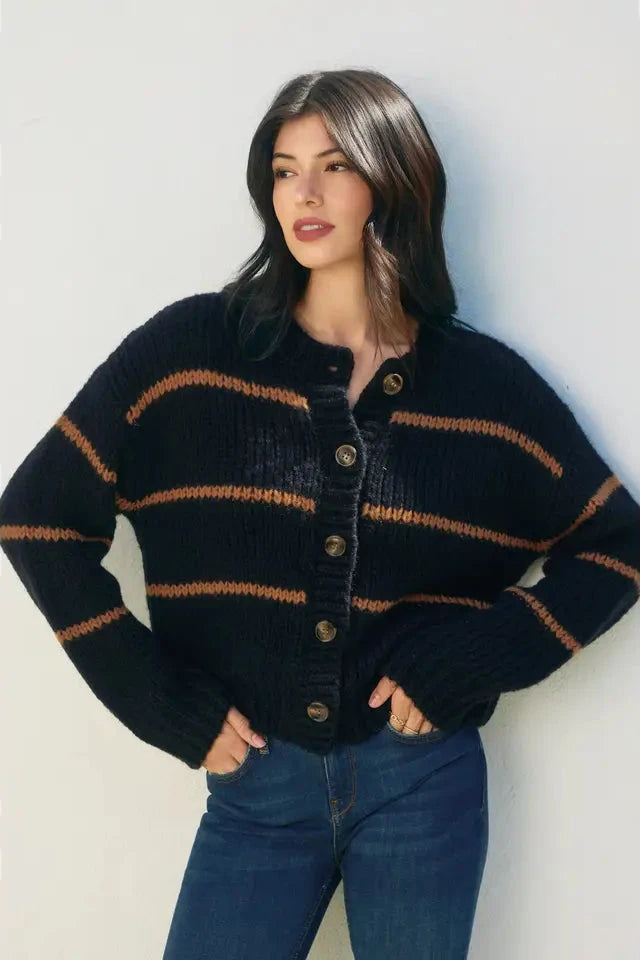 Woman wearing a black and orange striped sweater against a white background