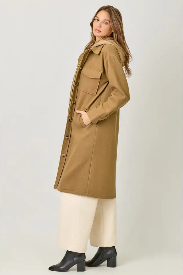 Woman wearing a long beige coat on a white background