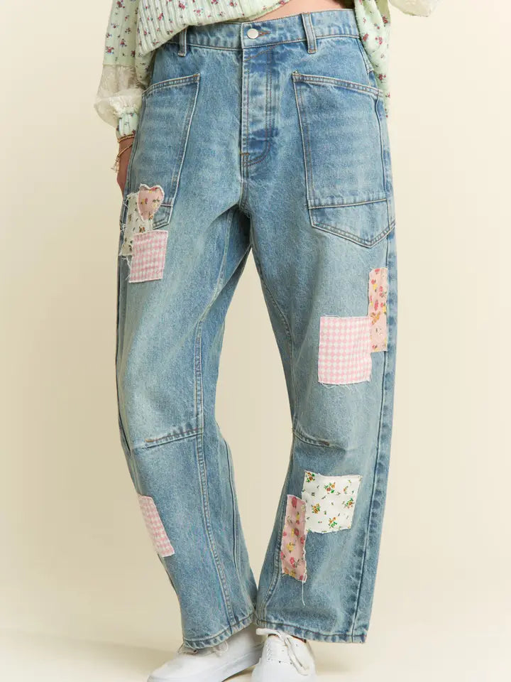 Blue jeans with patchwork design on a plain background