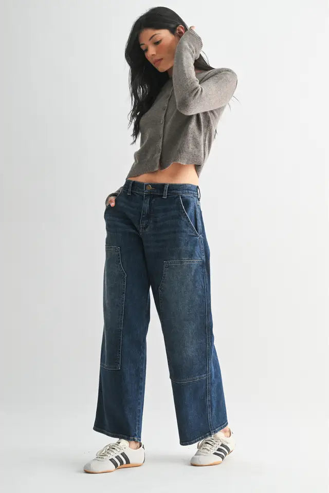 Woman wearing blue jeans and a gray cropped hoodie on a white background