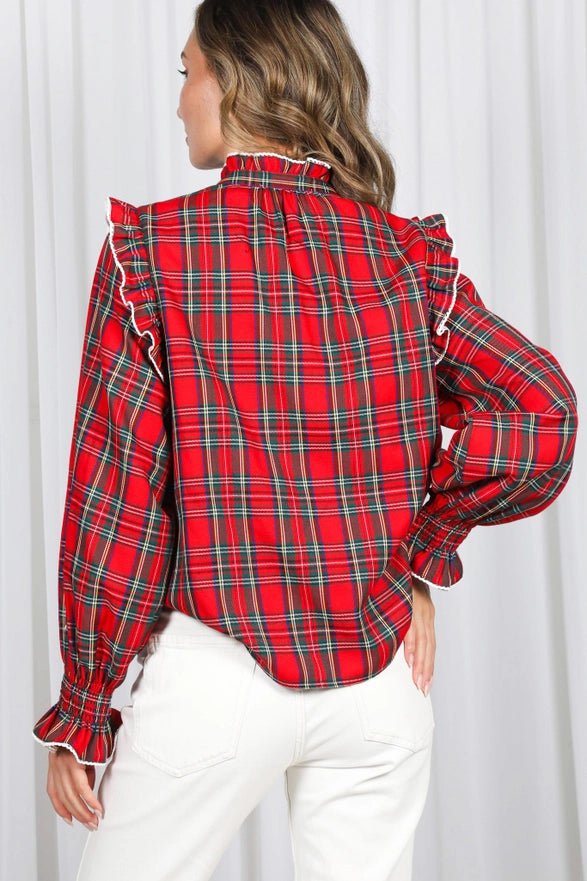Red plaid shirt with ruffled details worn by a person against a white background