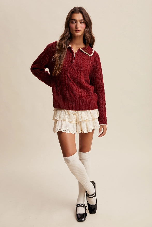 Woman wearing a red sweater, white skirt, and knee-high socks on a beige background