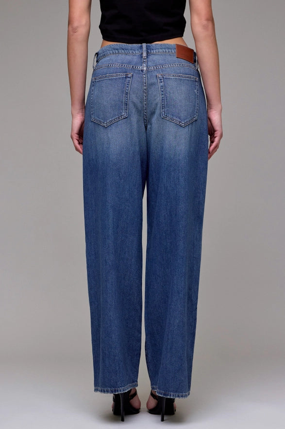 Person wearing blue jeans on a plain background