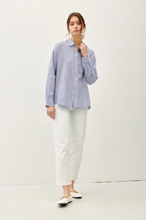 Woman wearing a blue checkered shirt and white pants on a white background