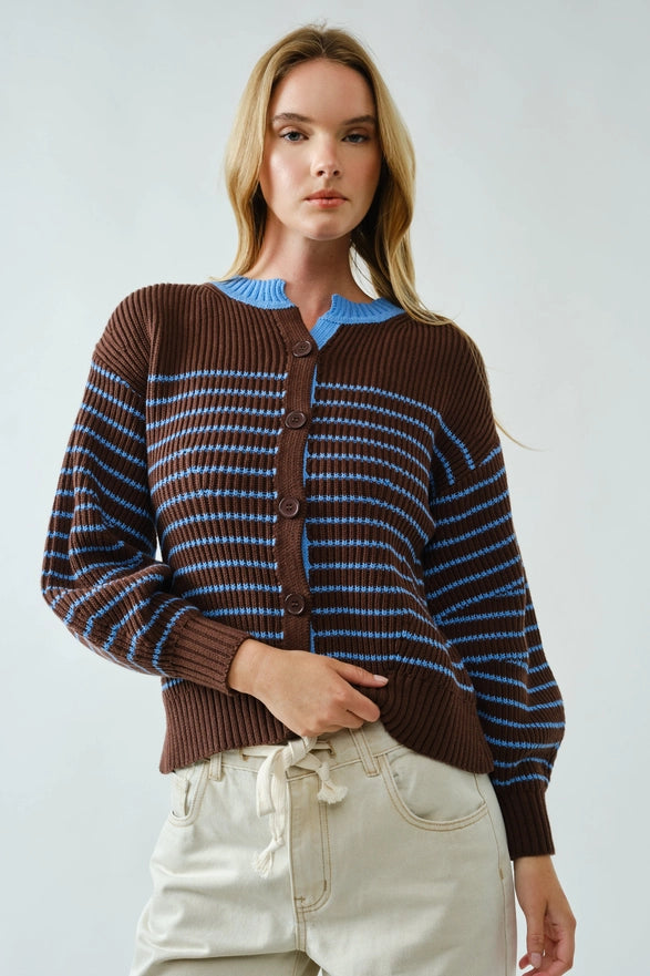 Woman wearing a brown and blue striped sweater against a white background