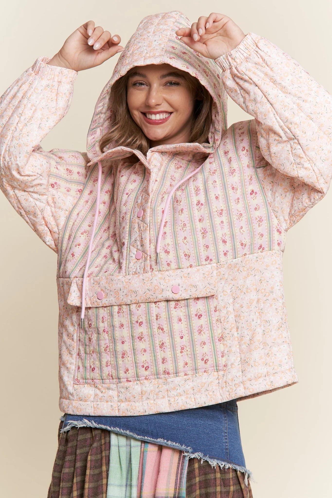 Woman wearing a floral quilted jacket against a plain background