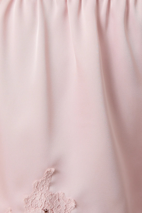 Close-up of light pink fabric with lace detailing