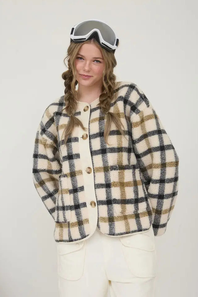 Person wearing a plaid jacket and goggles on a white background