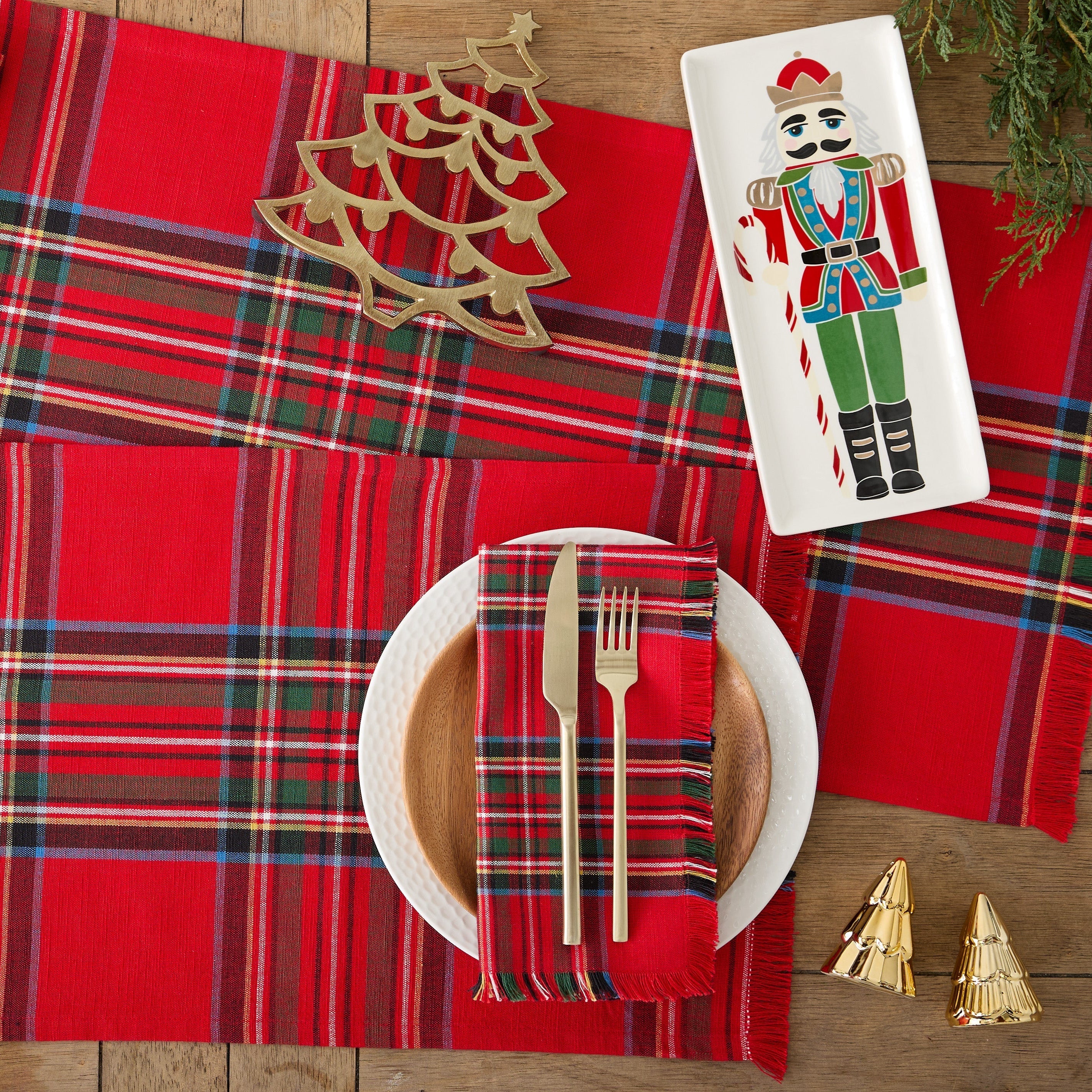 Red plaid tablecloth with Christmas decorations on a wooden table