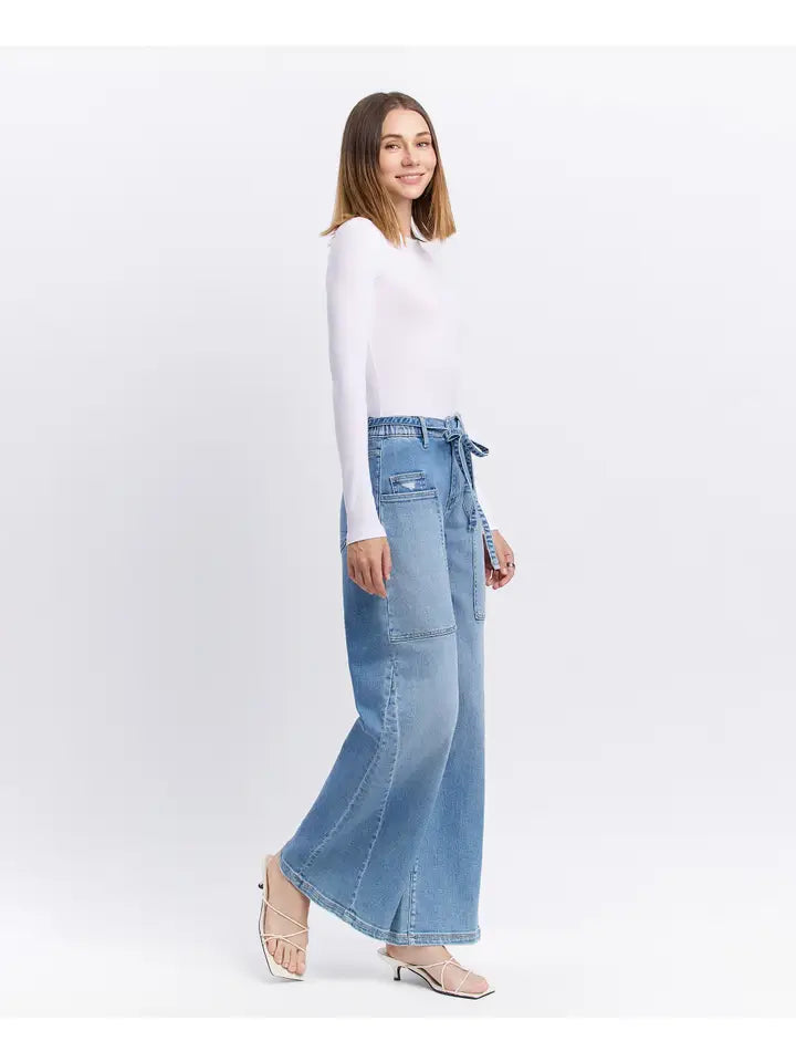 Woman wearing a white top and blue denim skirt on a white background