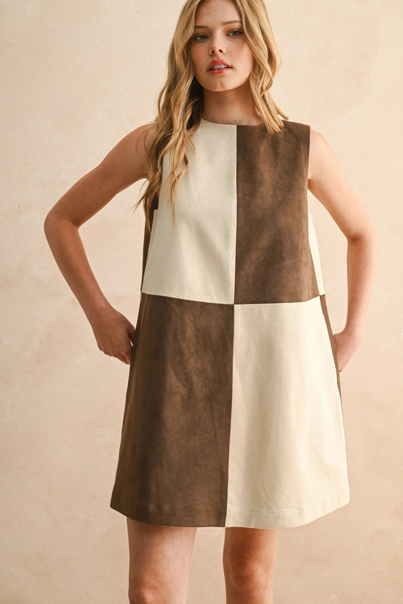 Woman wearing a checkered dress with brown and white pattern on a beige background