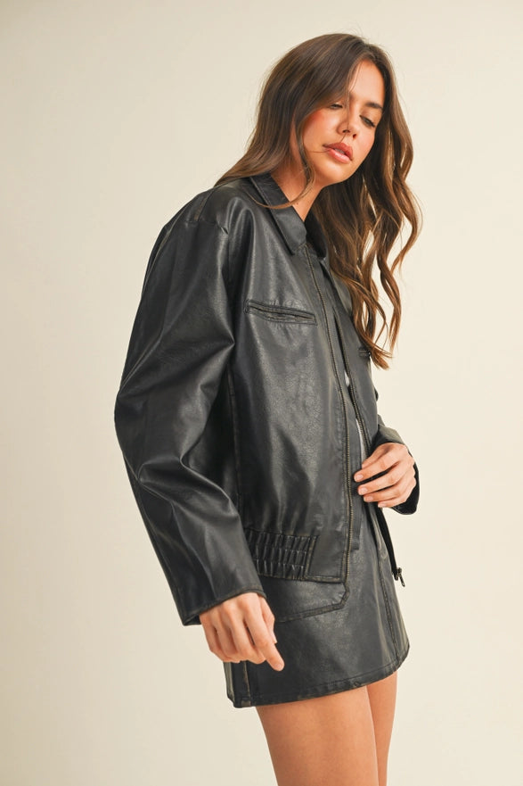 Woman wearing a black leather jacket on a beige background