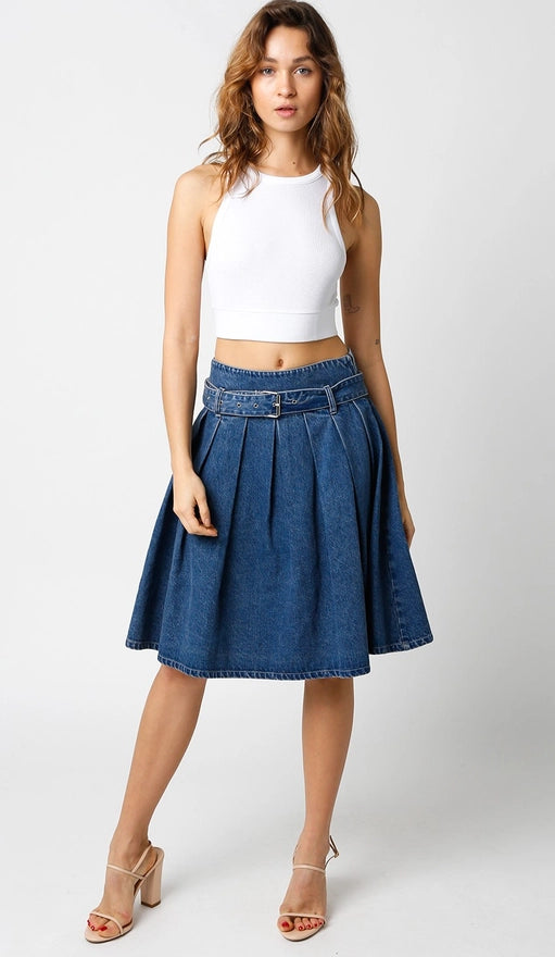 Woman wearing a white top and blue denim skirt on a white background