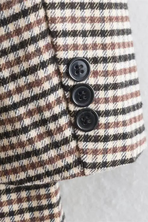 Plaid jacket with black buttons on a light gray background