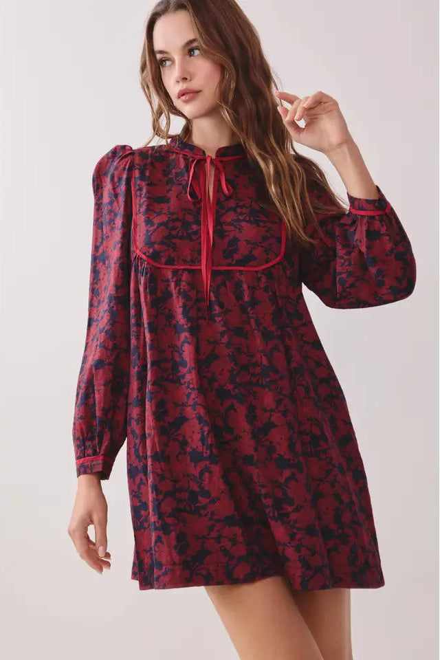 Red floral dress worn by a model on a white background