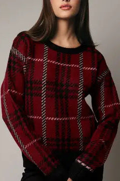 Person wearing a red plaid sweater against a neutral background