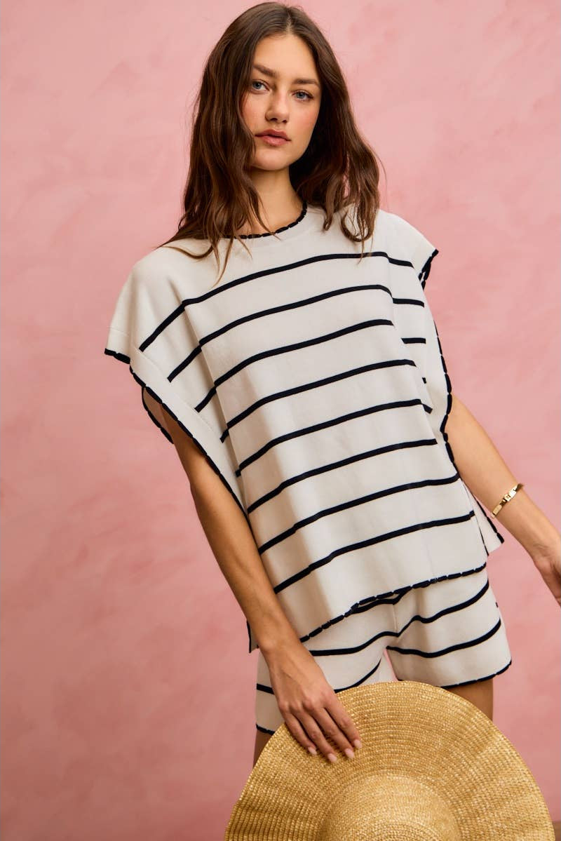 Woman wearing a black and white striped dress against a pink background