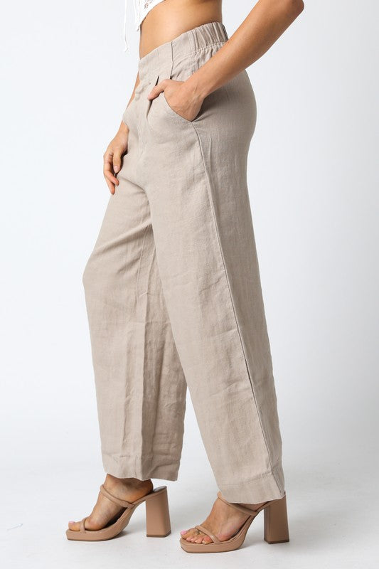 Beige wide-leg pants worn by a person on a white background
