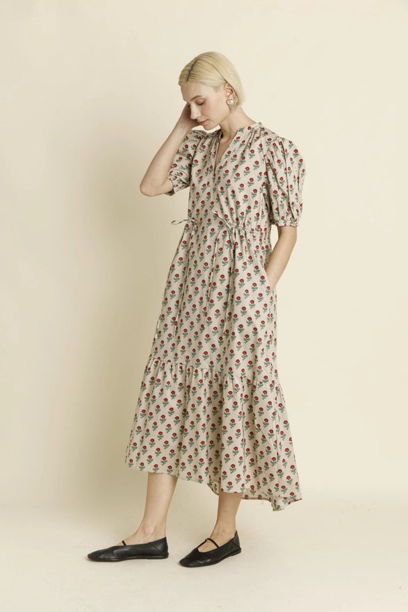 Woman wearing a floral dress against a plain background