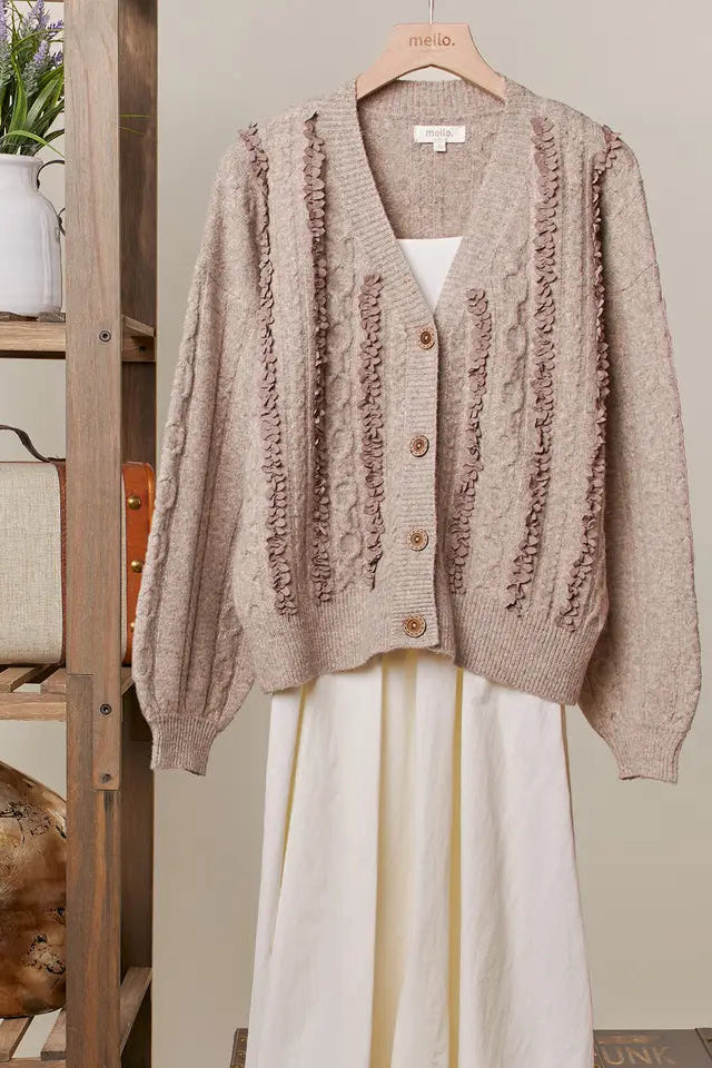 Brown knitted cardigan on a hanger with a neutral background