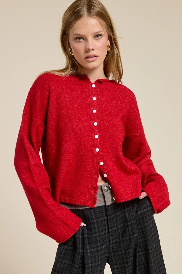Person wearing a red sweater with a beige background