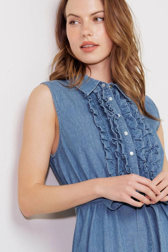 Woman wearing a blue denim dress with ruffled details on a white background