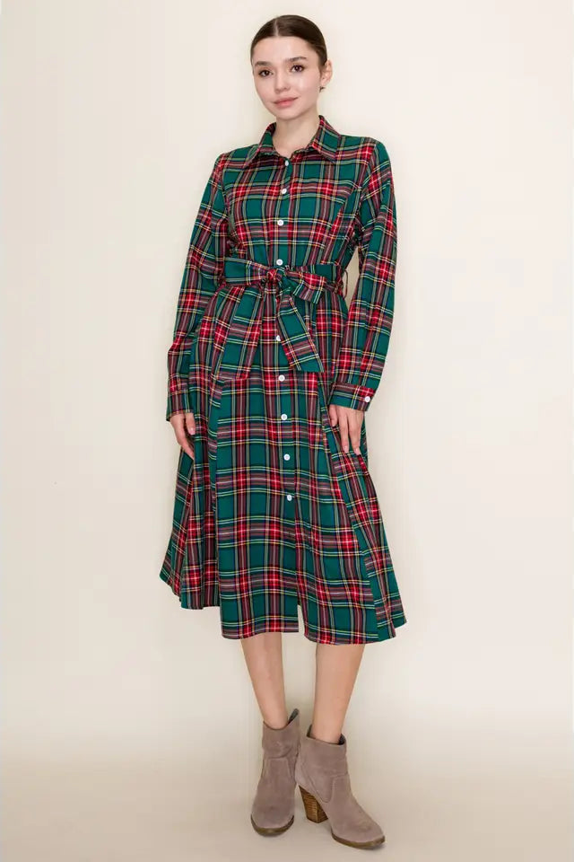 Woman wearing a green and red plaid dress against a beige background