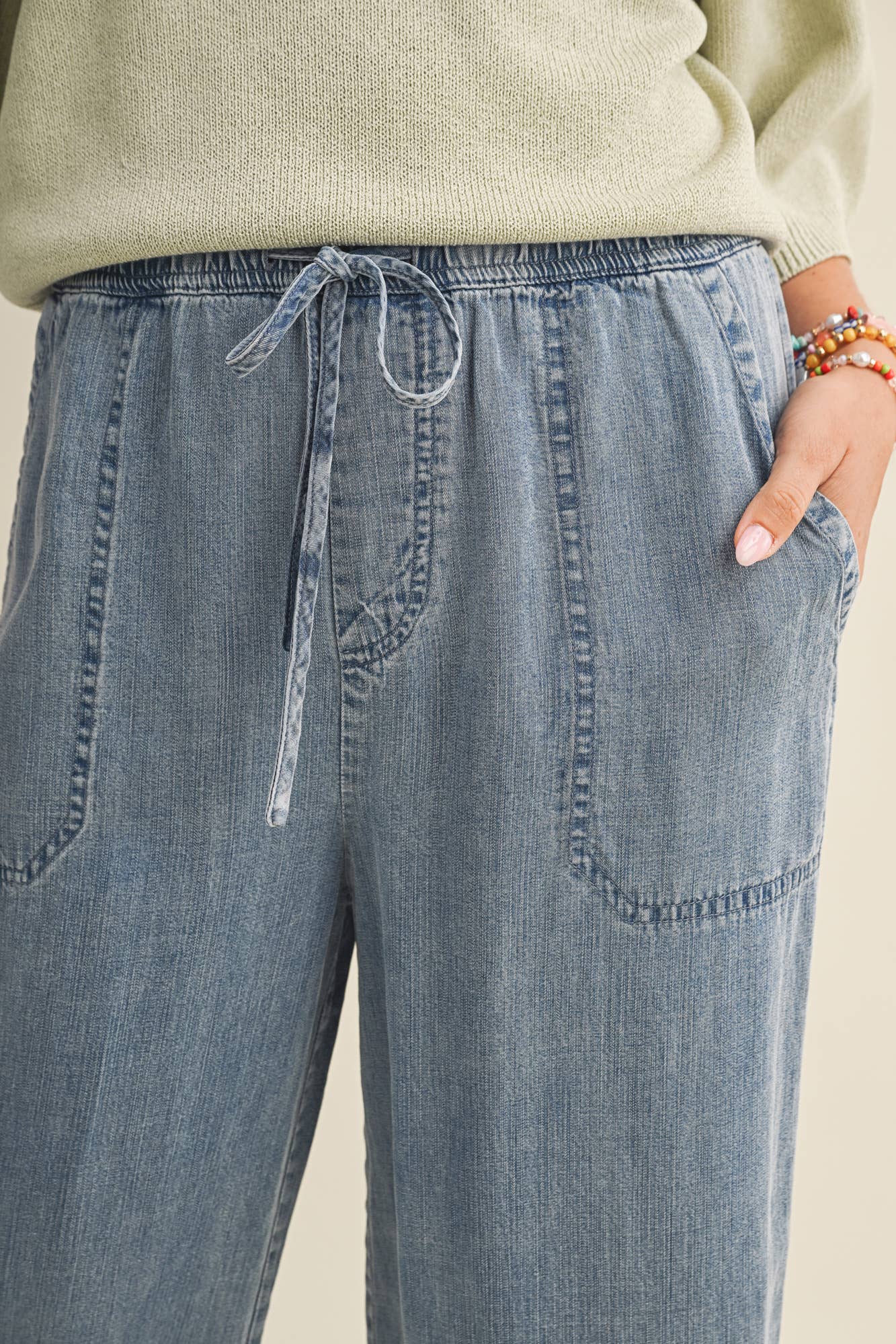 Close-up of blue denim pants with a neutral background