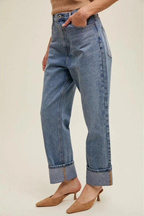 Person wearing blue jeans with a neutral background