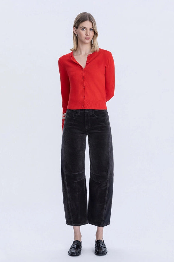 Woman wearing a red sweater and black pants on a white background
