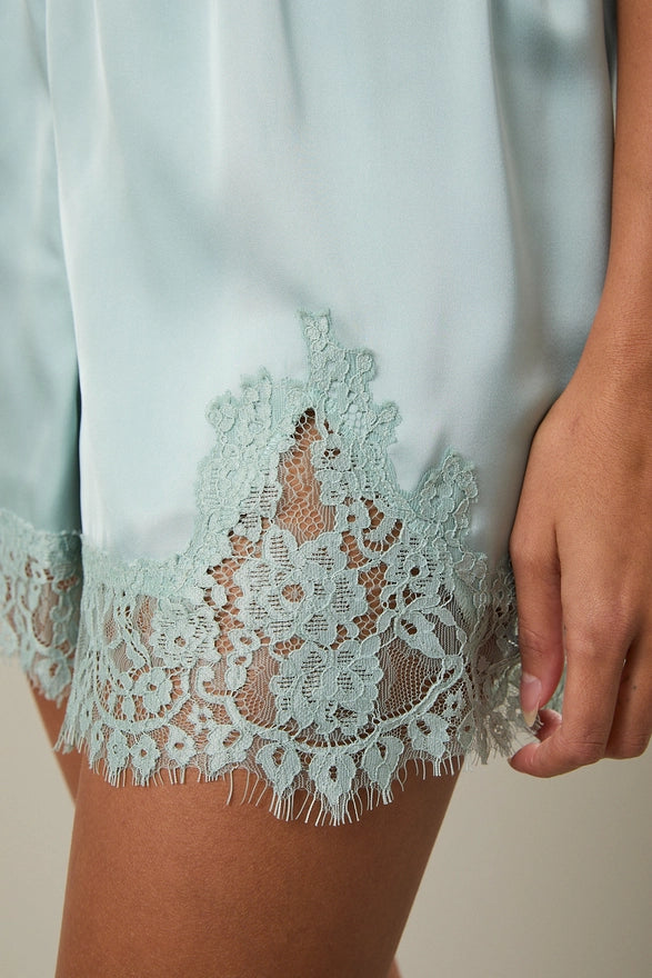 Light blue garment with lace detailing on a neutral background