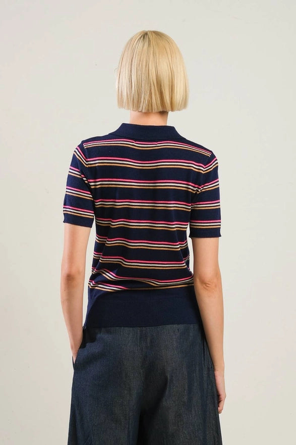 Person wearing a navy striped shirt with a plain background
