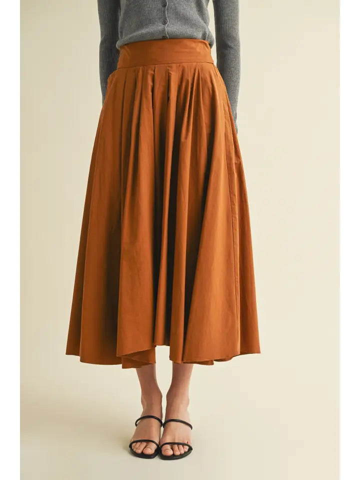 Person wearing a rust-colored skirt on a beige background