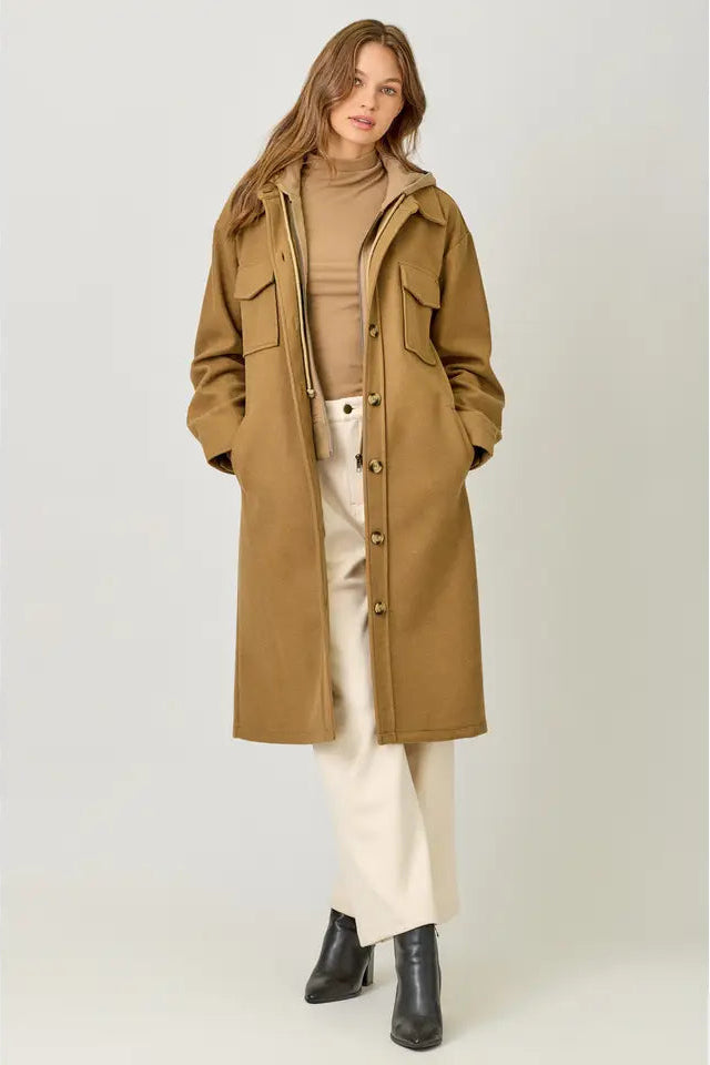 Woman wearing a long beige coat on a white background
