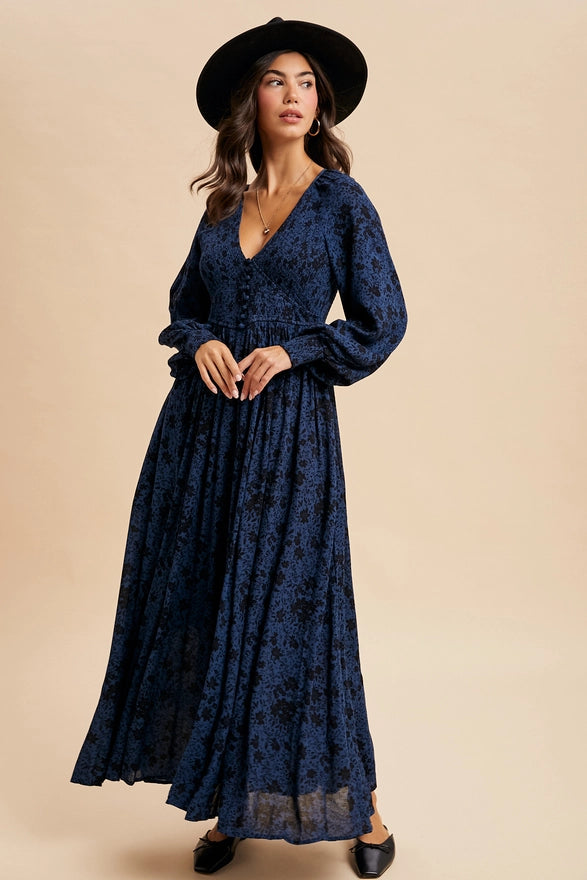 Woman wearing an indigo floral maxi dress on plain background.