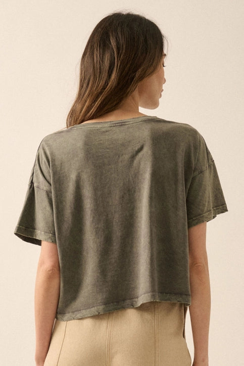 Woman wearing a green t-shirt against a beige background