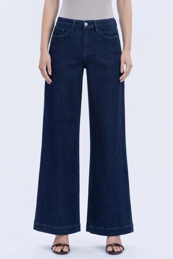 Person wearing dark blue wide-leg jeans on a white background