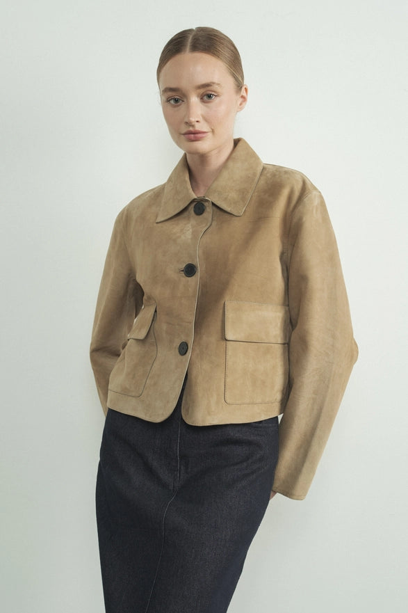 Woman wearing a brown jacket with black buttons on a white background