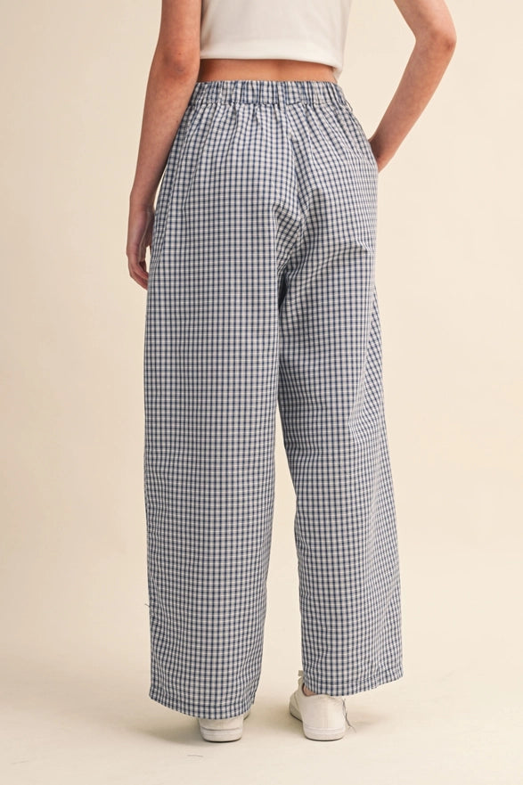 Person wearing blue checkered pants on a beige background