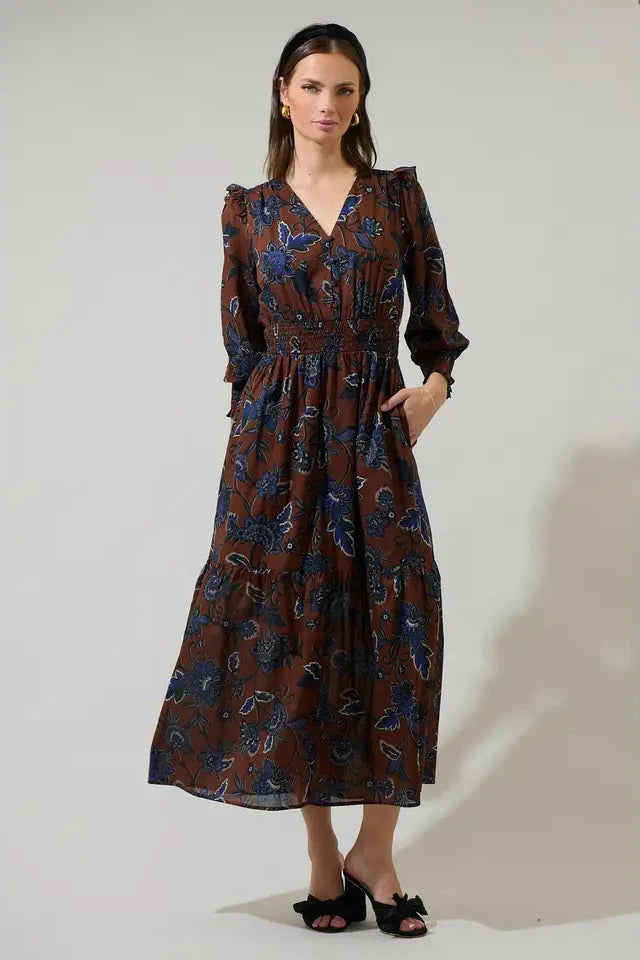 Woman wearing a patterned dress against a plain background