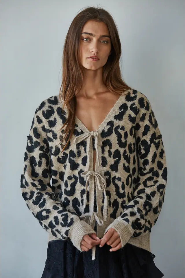 Woman wearing a leopard print sweater with a plain background