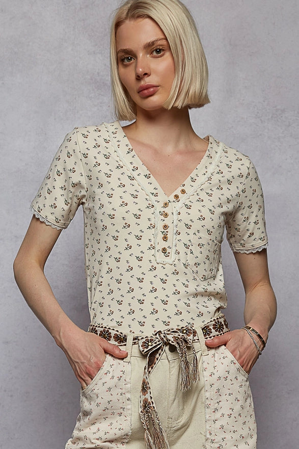 Woman wearing a floral dress with a belt against a gray background