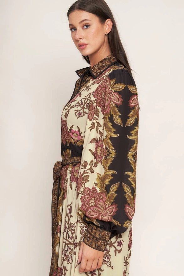 Woman wearing a long, patterned dress with a neutral background