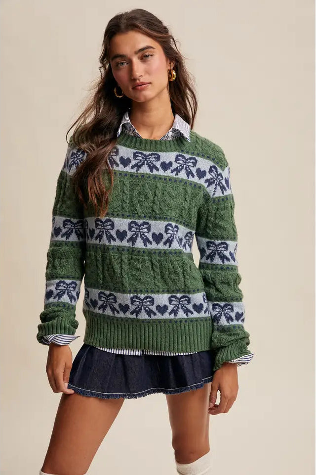 Woman wearing a green sweater with a pattern on a beige background