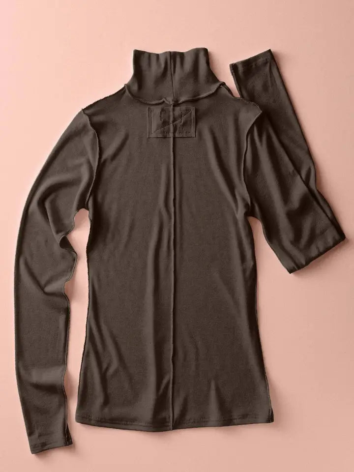 Brown long-sleeve top on a pink background