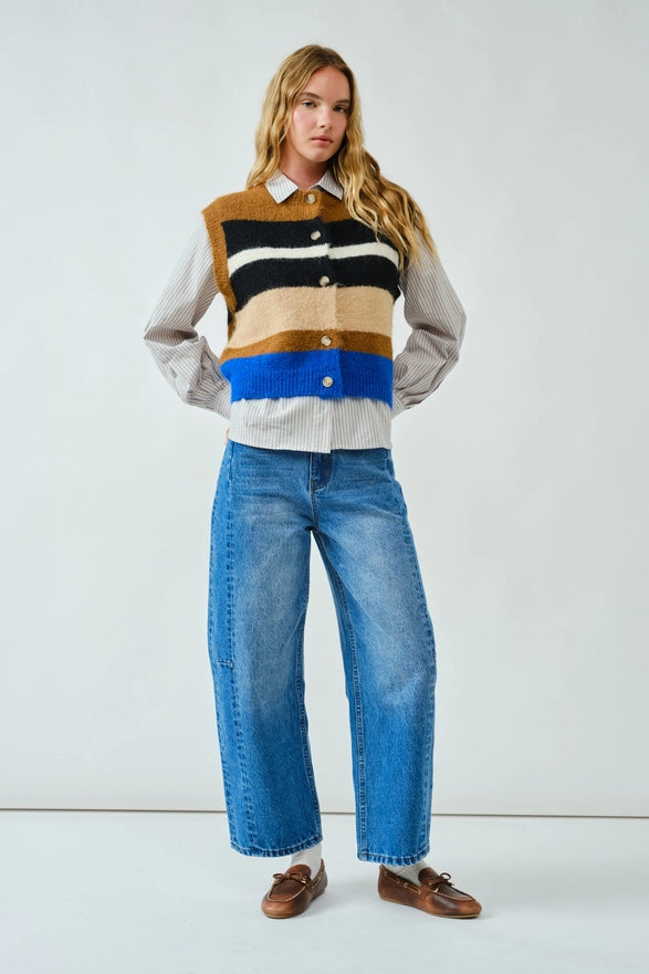 Woman wearing a striped sweater and blue jeans against a white background