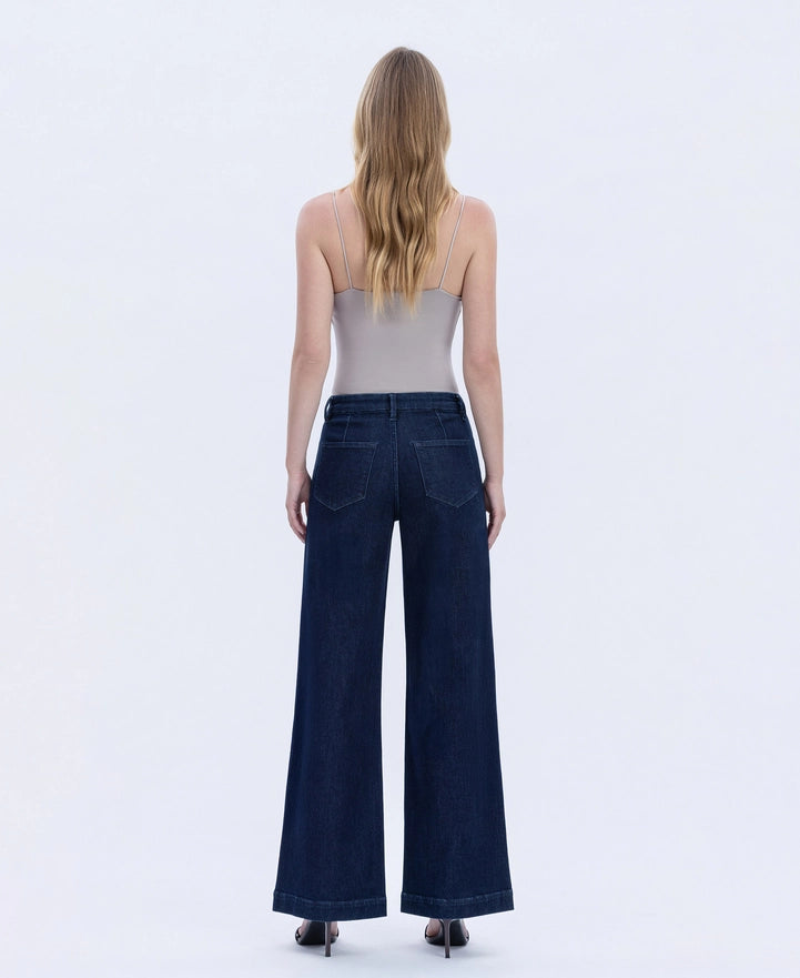 Woman wearing dark blue wide-leg jeans on a white background