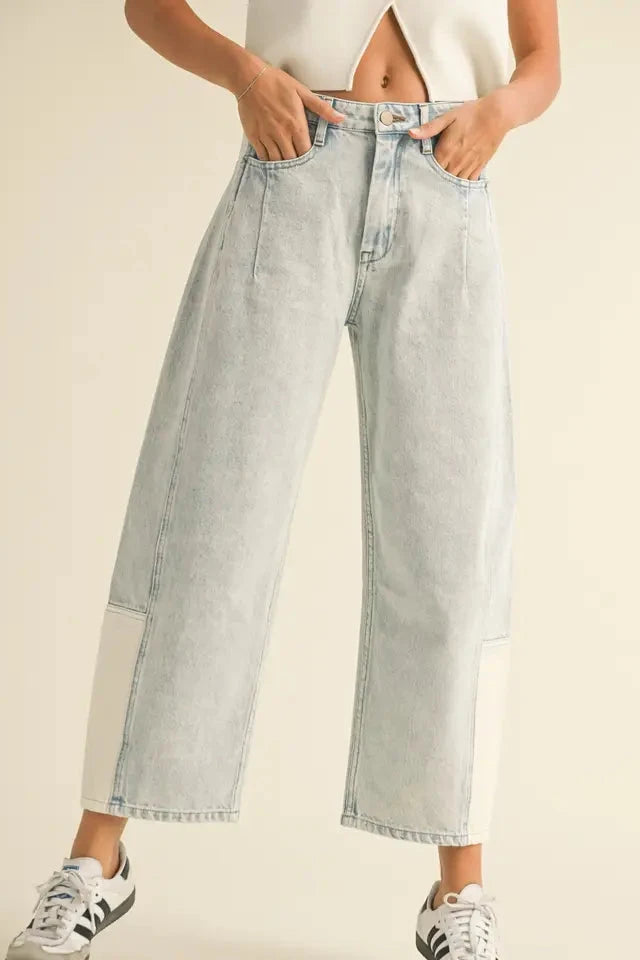 Light blue jeans worn by a person on a beige background