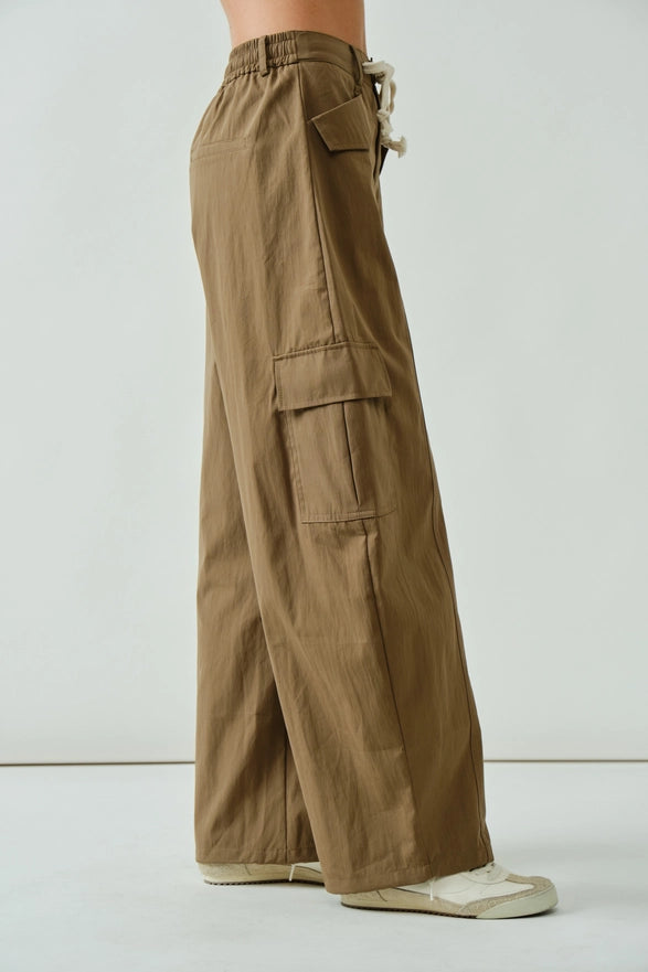 Brown cargo pants worn by a person on a white background